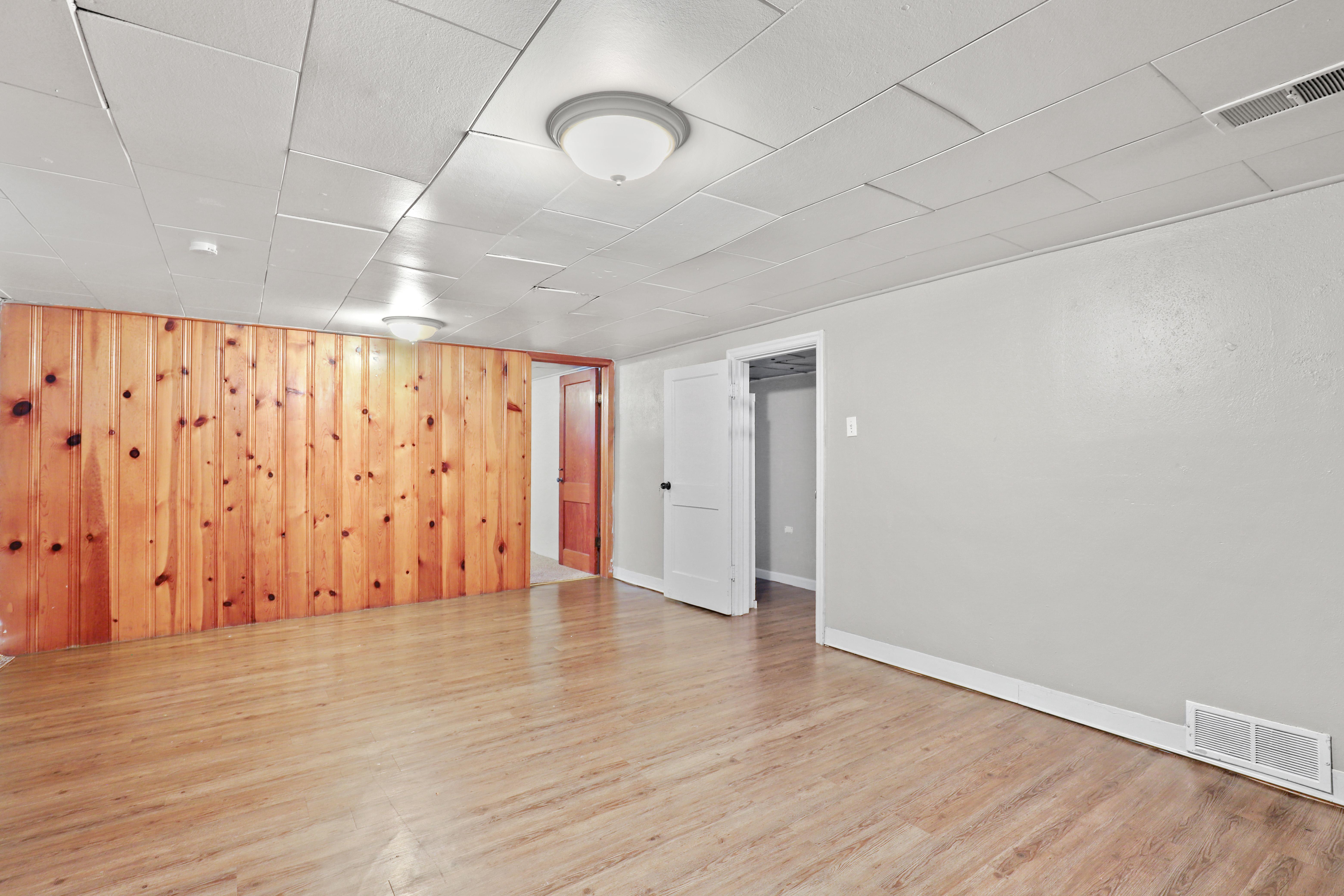 an empty room with wood floors and a wooden wall